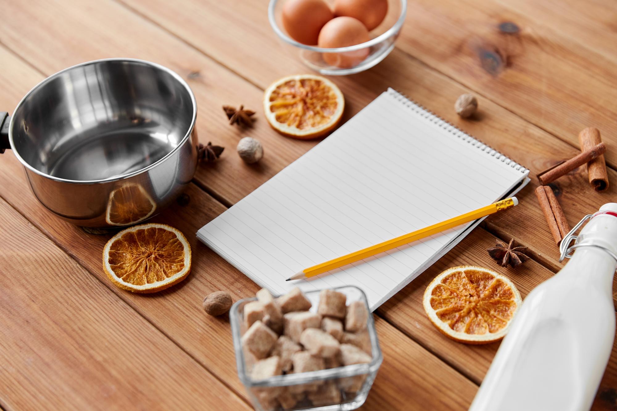 Mesa con equipos de cocina y cuaderno de recetas